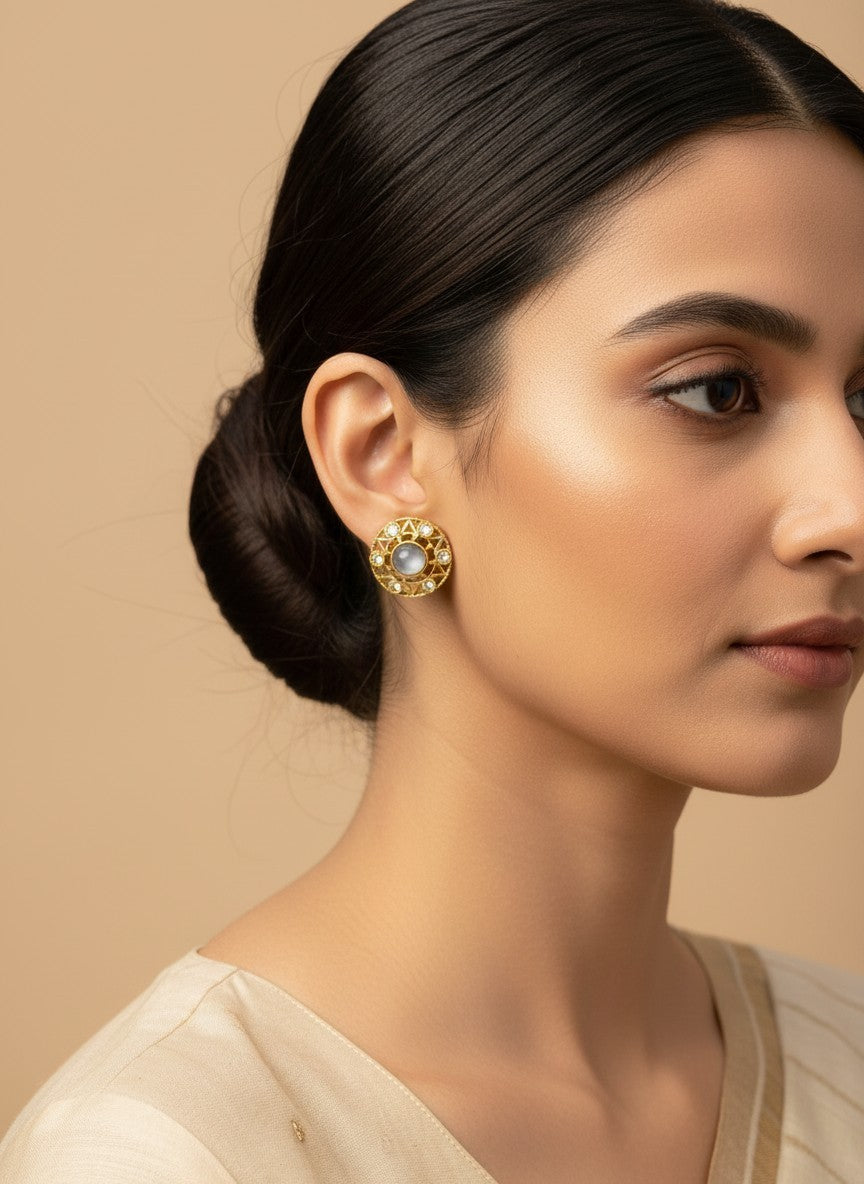 SHE BEAUTY antique gold-toned stud earrings with a central grey stone and intricate geometric detailing on a model