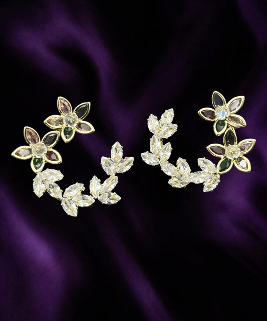 SHE BEAUTY KOREAN AD BLOOM floral earrings with multi-colored crystals and clear marquise stones on purple fabric