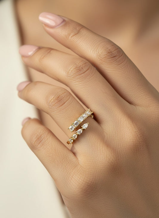 SHE BEAUTY gold-tone anti-tarnish ring featuring a bypass design with sparkling pear and rectangular cut AD stones.