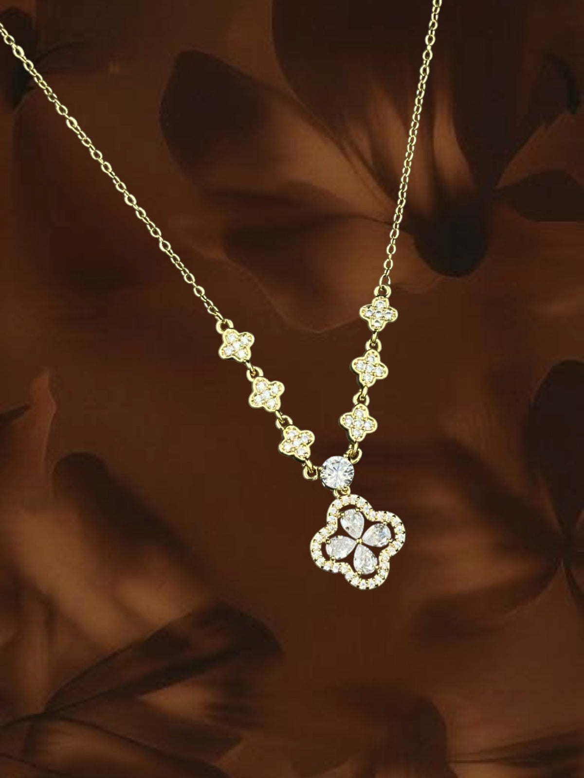 SHE BEAUTY gold-toned clover pendant necklace featuring sparkling AD stones in a delicate floral chain design.