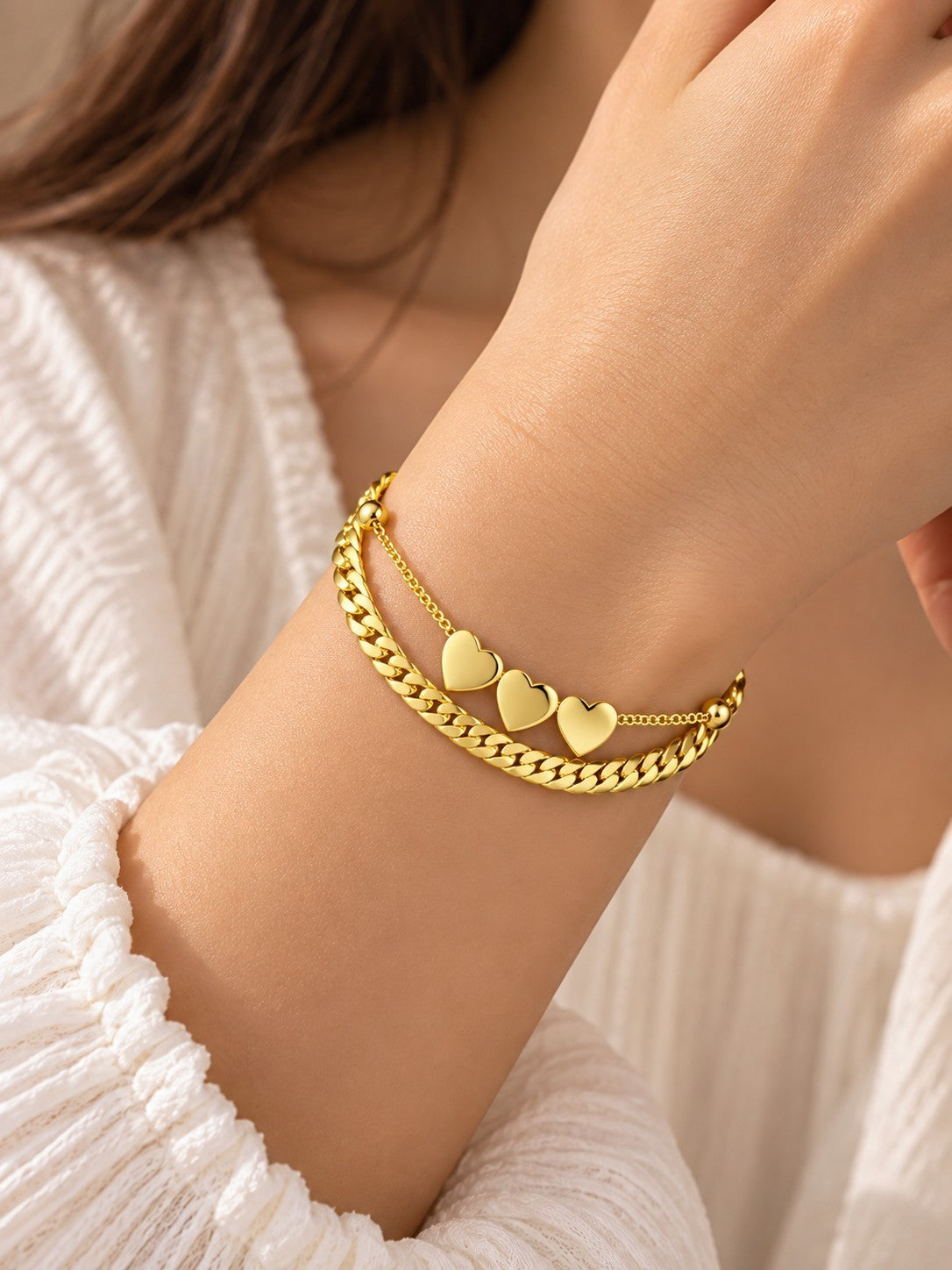 SHE BEAUTY KIYU ZIYU gold-tone chain bracelet featuring three delicate heart charms on a woman's wrist
