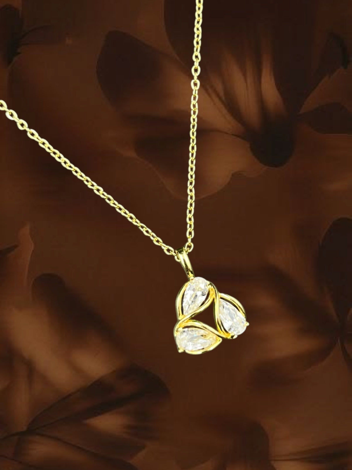SHE BEAUTY gold-toned AD petal pendant necklace featuring three pear-cut clear stones in a floral arrangement