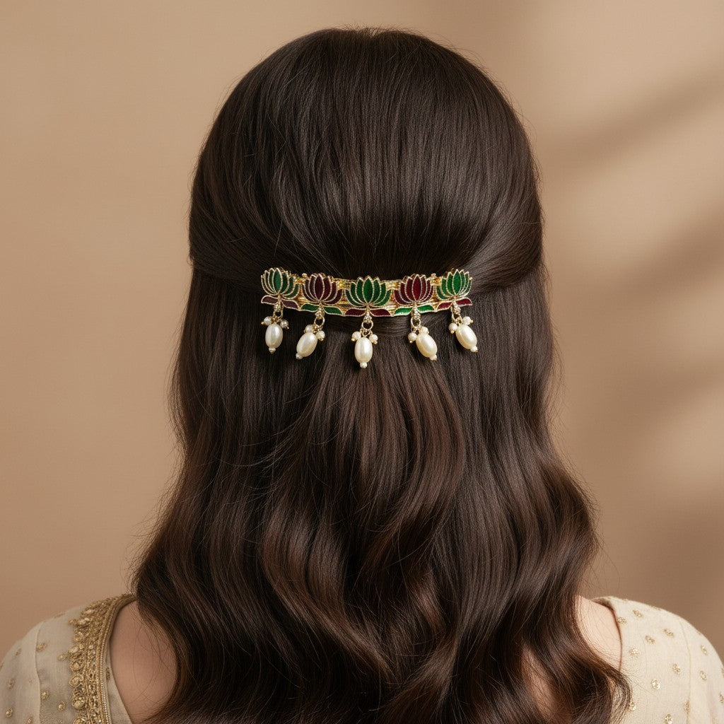 SHE BEAUTY lotus meenakari barrette with red and green enamel detailing and hanging white pearls on wavy brown hair