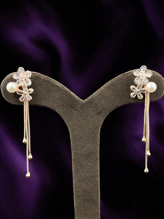 SHE BEAUTY AD Bloom Trail earrings featuring rose gold flower motifs, sparkling stones, and delicate pearl drops.