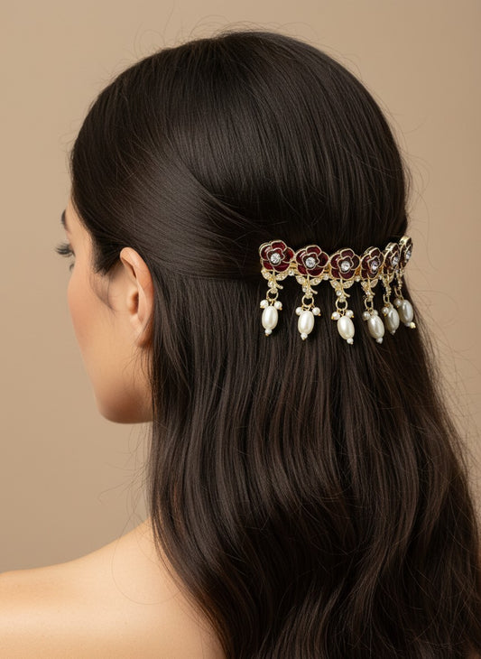SHE BEAUTY AD rose meenakari barrette with red floral enamel, sparkling stones, and dangling white pearls in hair.