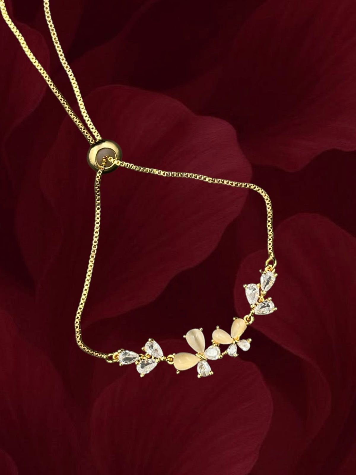 SHE BEAUTY Zirconia Flora bracelet with gold-tone chain, floral crystal accents, and adjustable sliding clasp.