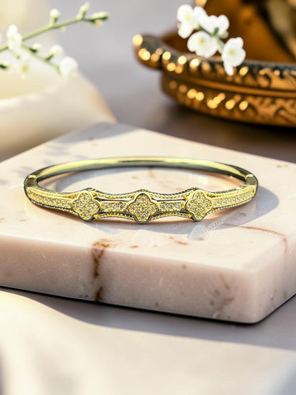 SHE BEAUTY anti-tarnish gold-tone AD bracelet featuring intricate clover-shaped motifs with sparkling stone accents.