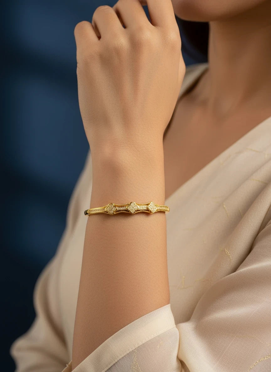 SHE BEAUTY anti-tarnish gold-tone AD bracelet with clover-shaped stone accents worn on a woman's wrist