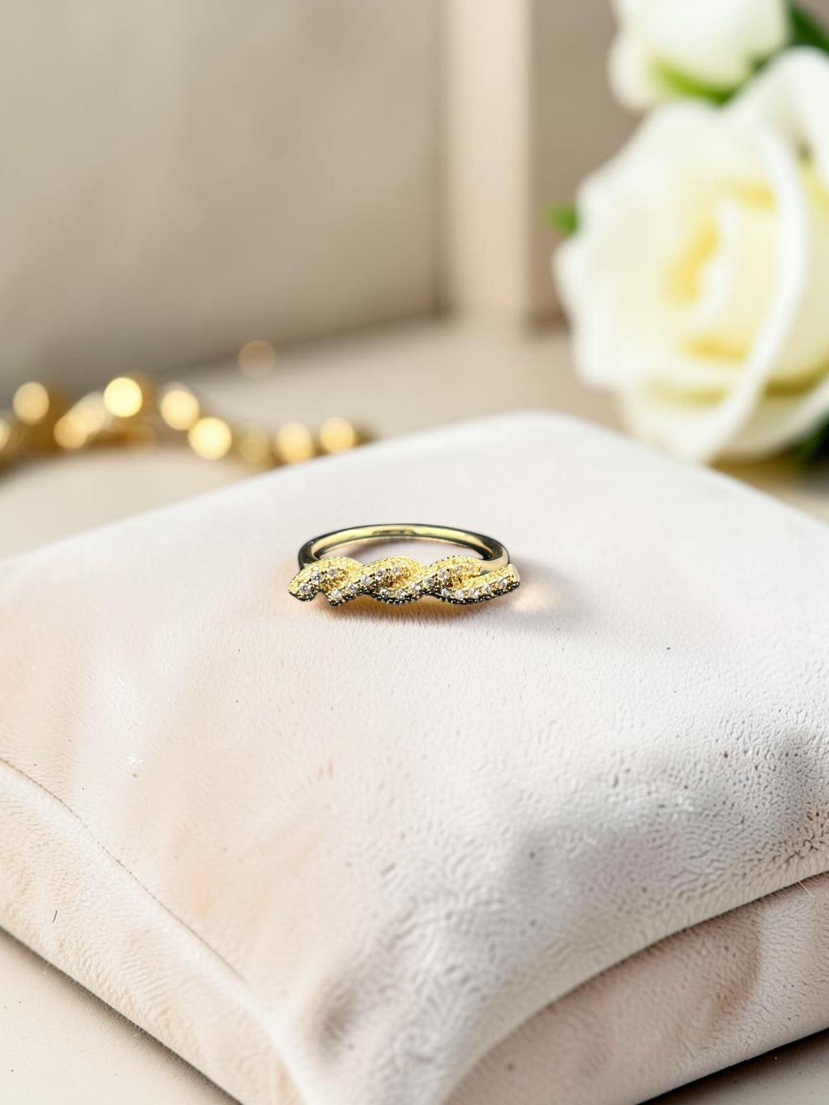 SHE BEAUTY anti-tarnish ring featuring a twisted gold-tone band with sparkling AD stones on a velvet display cushion.