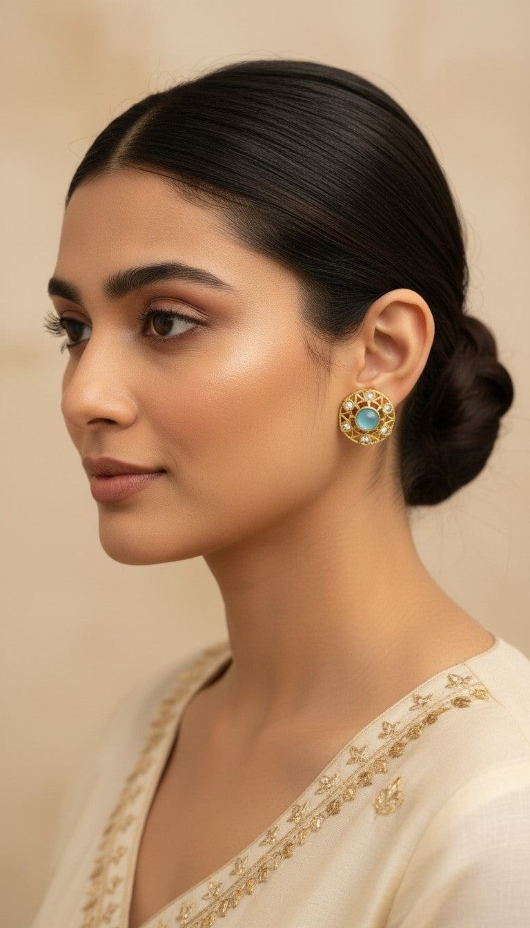 SHE BEAUTY antique gold-toned stud earrings with a central light blue stone and intricate filigree detailing.