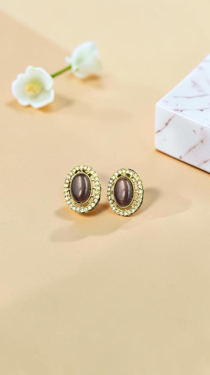 SHE BEAUTY AD antique oval tops featuring a central grey stone surrounded by sparkling crystals in a gold-tone finish.