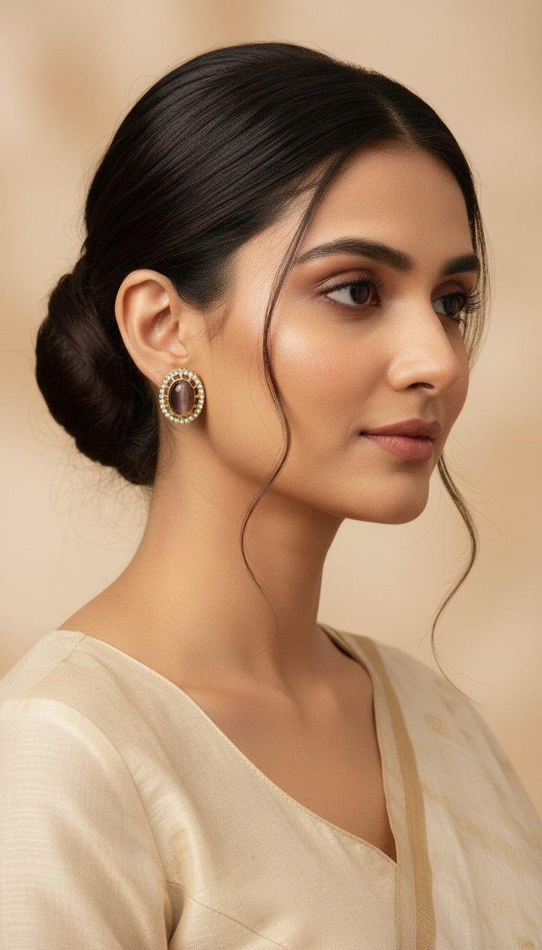 SHE BEAUTY AD antique stud earrings with a central oval stone and pearl border worn by a woman in a beige saree