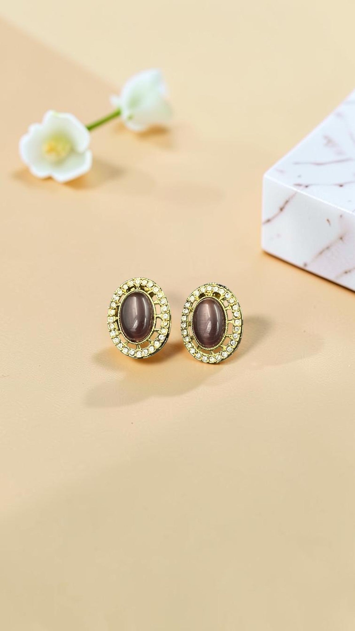 SHE BEAUTY AD antique tops featuring oval grey stones surrounded by sparkling crystals in a gold-tone setting.