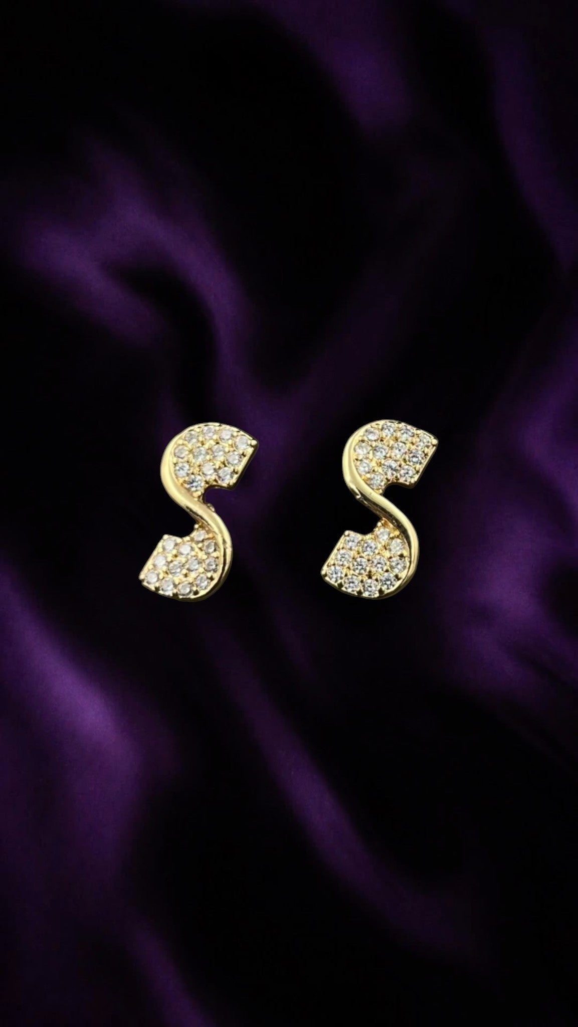 SHE BEAUTY Celeste dangles featuring gold-tone S-shaped earrings encrusted with sparkling white stones on purple silk
