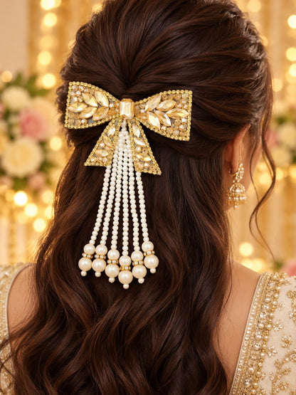 SHE BEAUTY AD Coquette pearl hair pin featuring a gold bow with crystals and dangling pearl strands on brunette hair