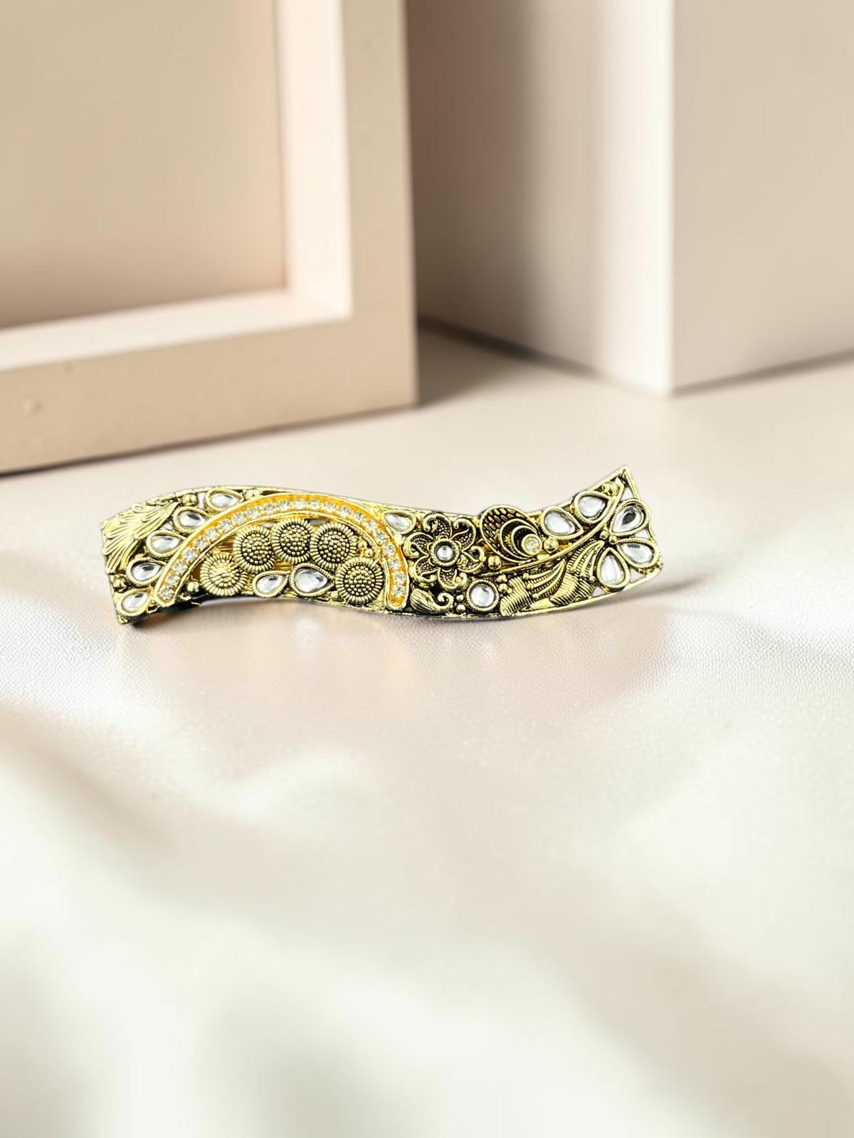SHE BEAUTY curved vintage metallic barrette with intricate floral engravings and white stone accents for festive wear