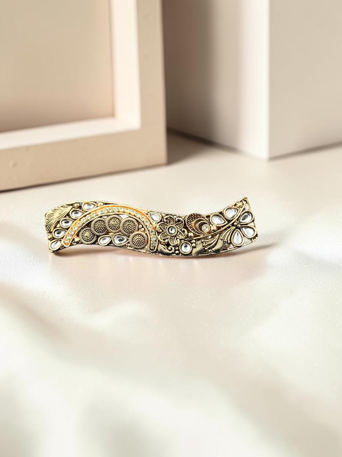 SHE BEAUTY curved vintage metallic barrette with intricate floral engravings and white stone accents for festive wear.