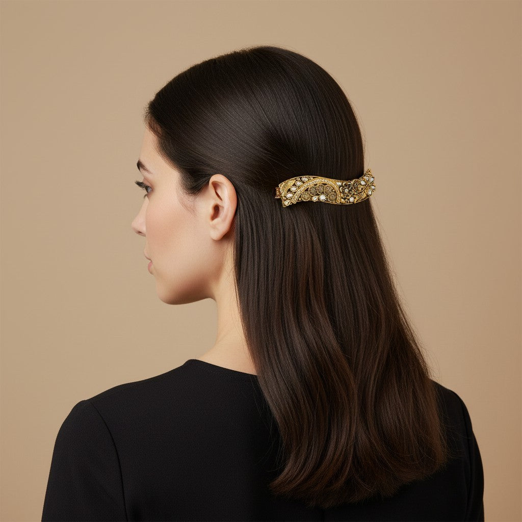 SHE BEAUTY curved vintage metallic barrette with intricate gold filigree and pearl accents worn in dark hair