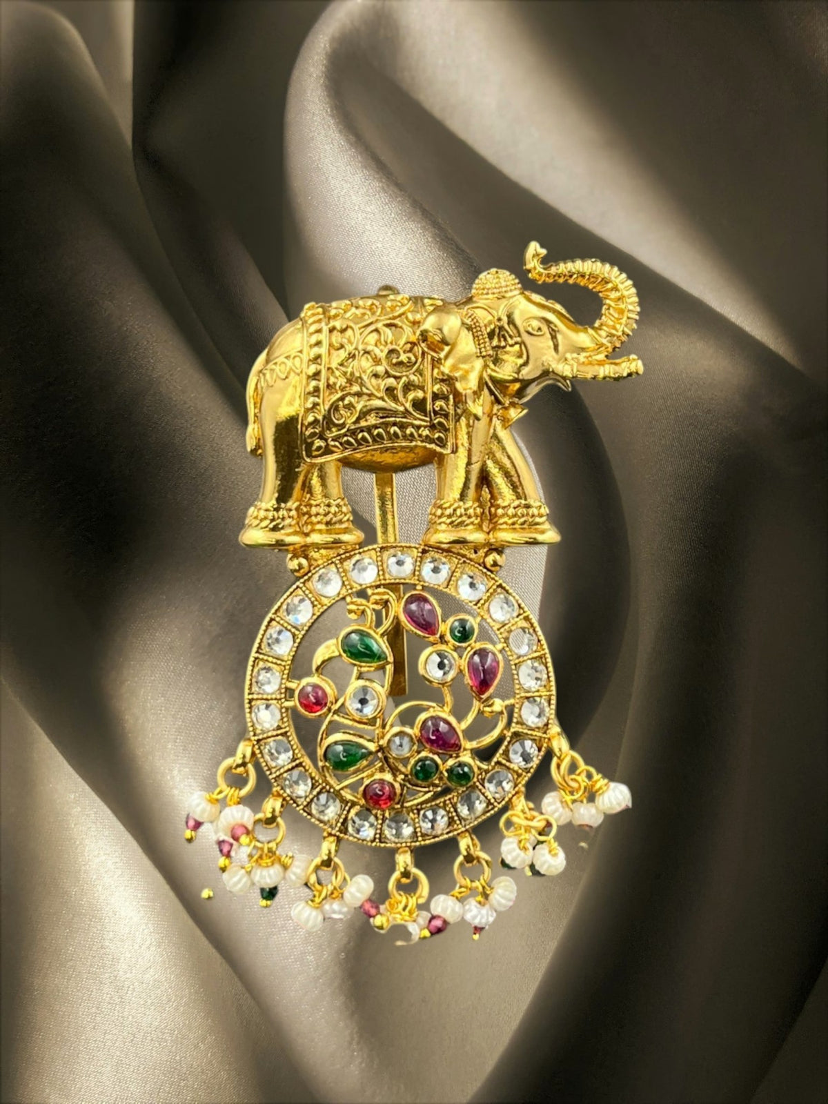 SHE BEAUTY gold-toned elephant hair brooch featuring ruby, emerald, and white stones with delicate pearl accents.