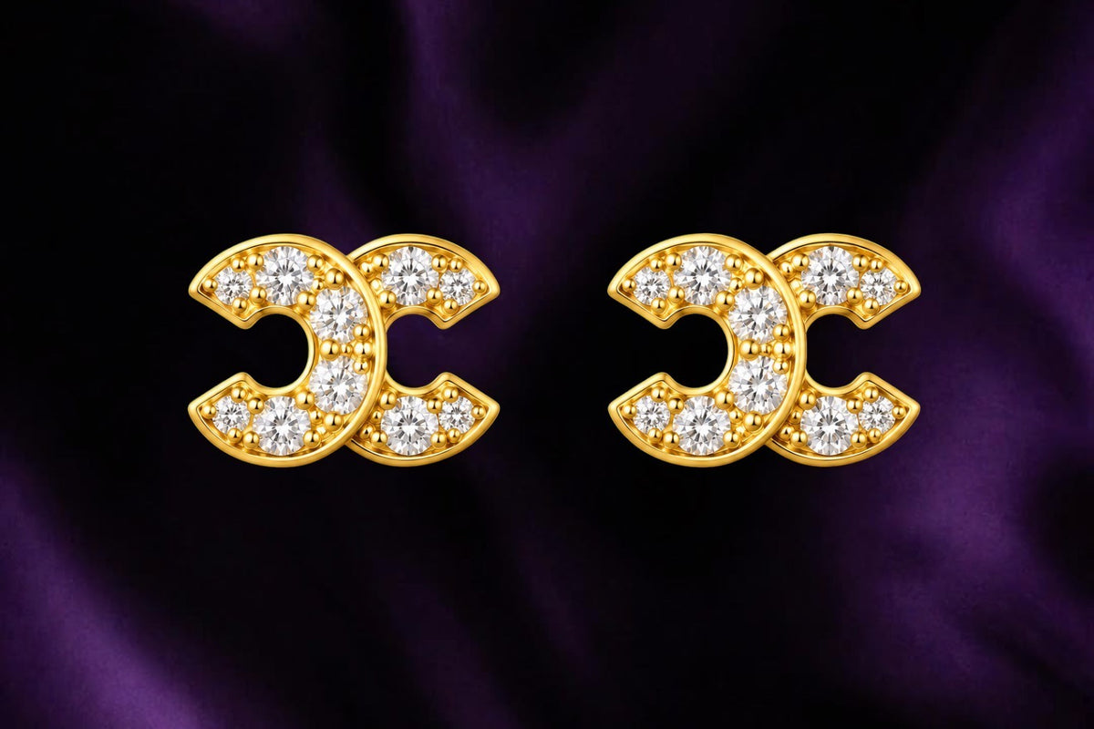 SHE BEAUTY ELITE STUDS gold-toned earrings featuring a double-C interlocking design with sparkling clear crystals.