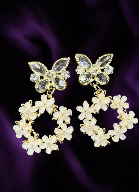 SHE BEAUTY Flora butterfly earrings featuring crystal-embellished butterflies and white floral wreaths in gold tone