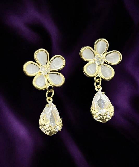 SHE BEAUTY FLORA DROP earrings featuring gold-tone flower studs with white petals and dangling crystal teardrops.