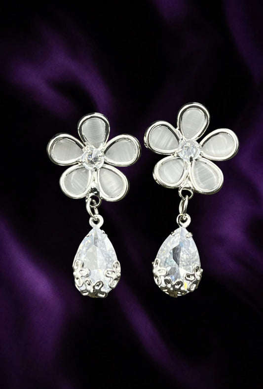 SHE BEAUTY Flora drop earrings featuring silver flower studs with white petals and dangling pear-shaped crystals.