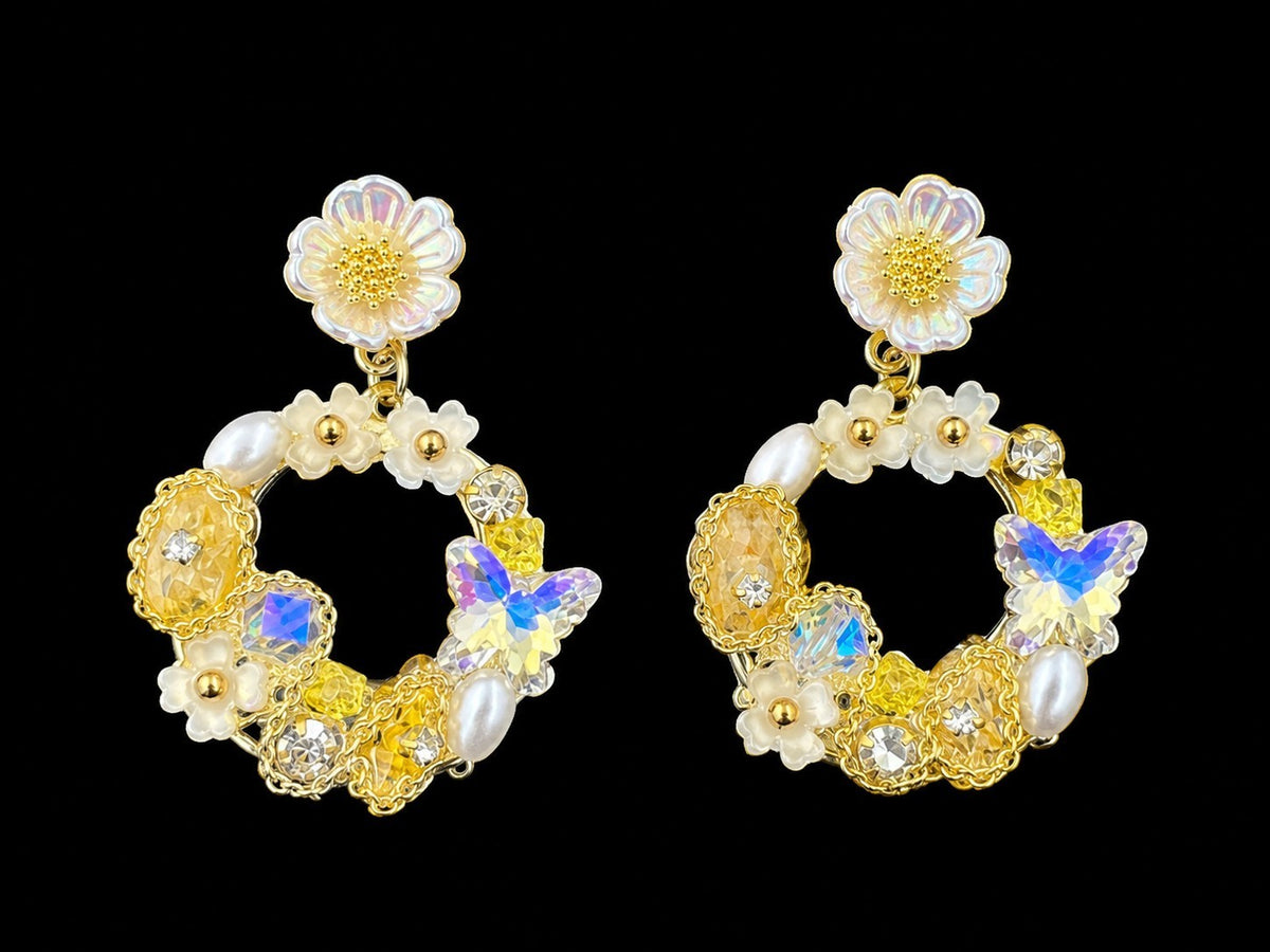 SHE BEAUTY Floral Arc earrings featuring yellow crystals, white pearls, and iridescent butterfly charms in gold tone
