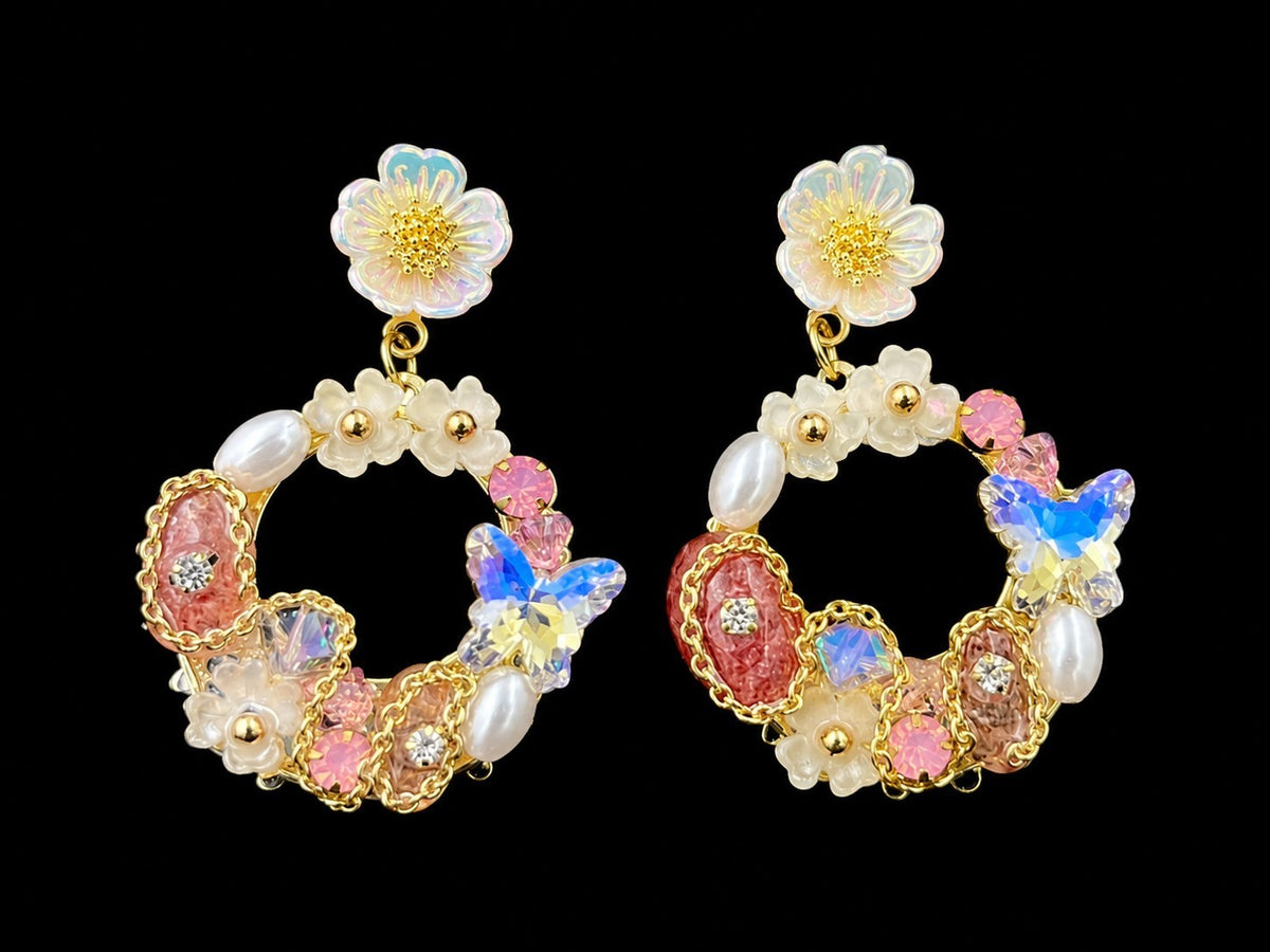 SHE BEAUTY FLORAL ARC earrings featuring iridescent butterfly charms, faux pearls, and pink crystals on gold hoops.