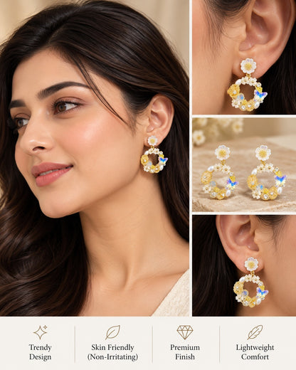 SHE BEAUTY Floral Arc earrings featuring white daisy studs, gold hoops with pearls, and blue butterfly accents.