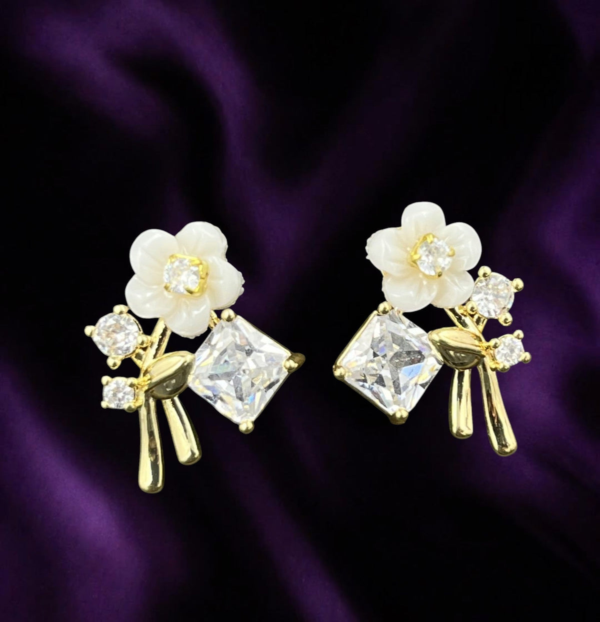 SHE BEAUTY EXCLUSIVE 925POST floral stud earrings with white petals, clear crystals, and gold-tone metal finish.