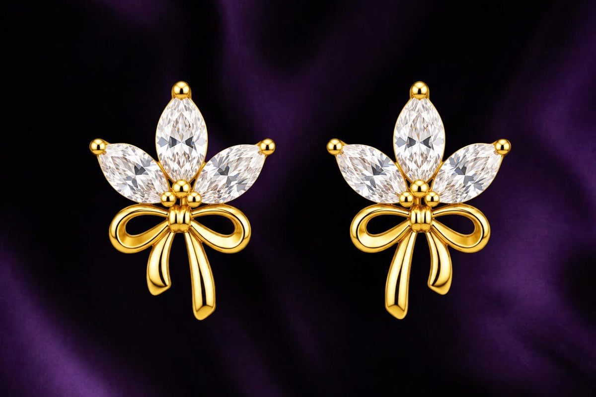 SHE BEAUTY FLORAL GLEAM gold-toned stud earrings featuring marquise-cut white crystals and a delicate bow design