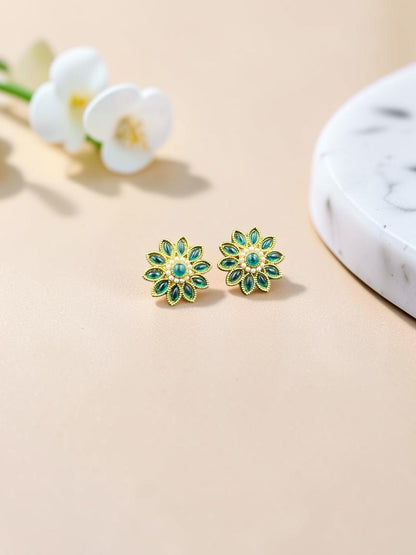 SHE BEAUTY floral stud earrings featuring green marquise stones and pearl accents in a gold-tone setting
