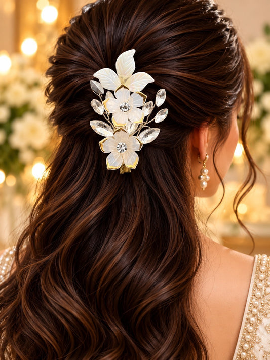 SHE BEAUTY floral vine hair pin with white petals, pearl accents, and sparkling crystals worn in wavy brown hair.