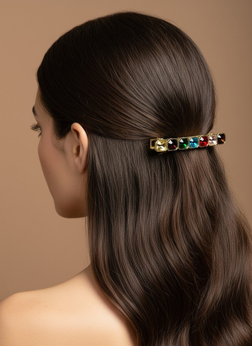 SHE BEAUTY barrette featuring seven colorful square gemstones worn in long dark hair for a festive look