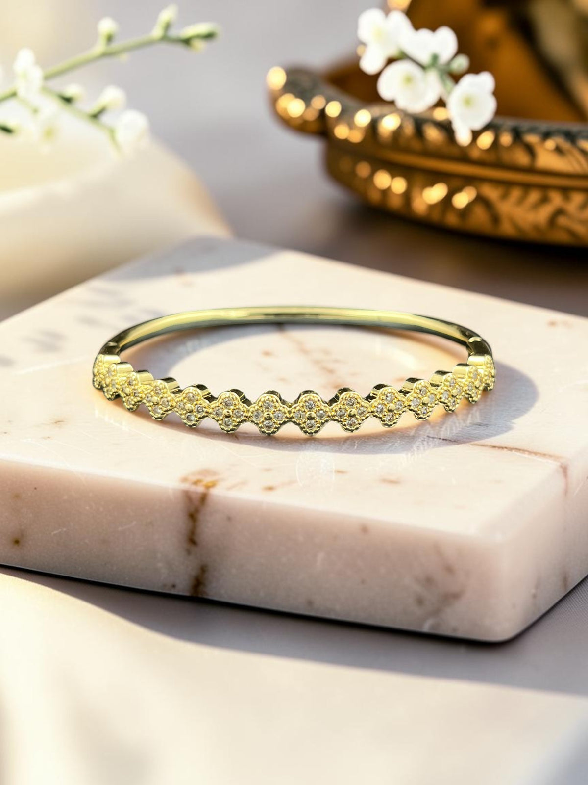 SHE BEAUTY anti-tarnish gold-tone AD bracelet with delicate scalloped edges and sparkling stone accents on marble