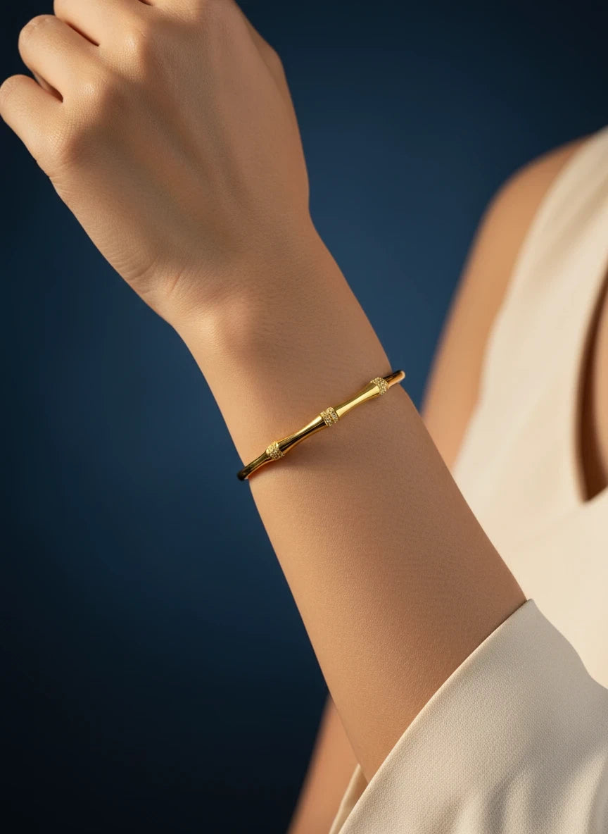 SHE BEAUTY gold-toned anti-tarnish AD bracelet with delicate textured accents worn on a woman's wrist.