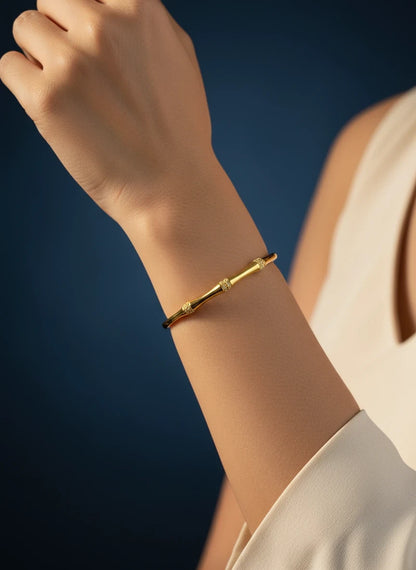 SHE BEAUTY gold-toned anti-tarnish AD bracelet with delicate textured accents worn on a woman's wrist.
