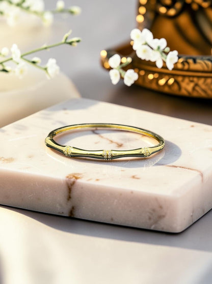 SHE BEAUTY anti-tarnish gold-tone AD bracelet with delicate crystal accents on a marble display stand