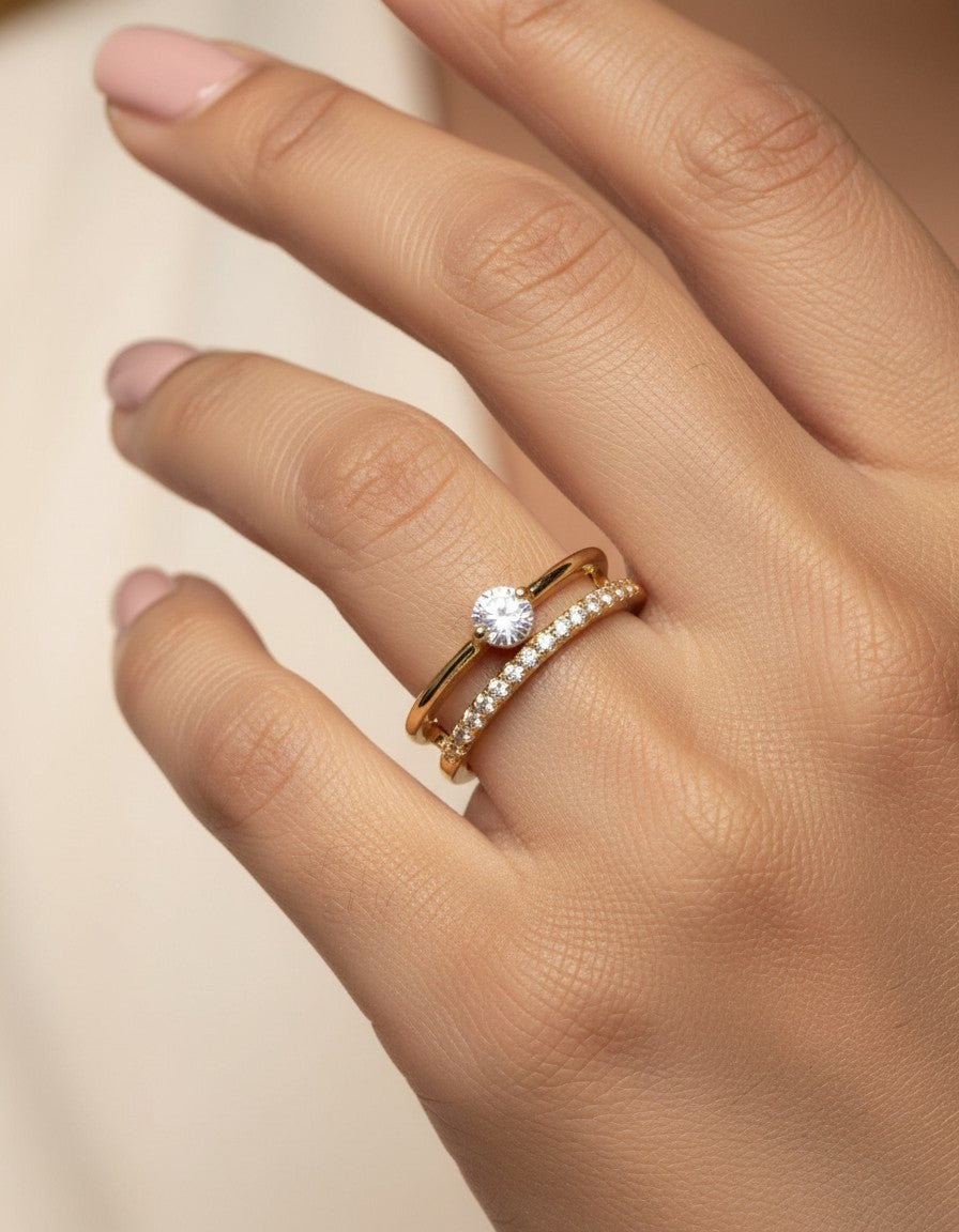 SHE BEAUTY anti-tarnish gold-toned ring set featuring a solitaire stone and a delicate pavé band on a woman's hand.