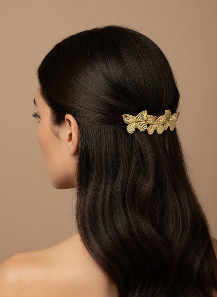 SHE BEAUTY gold metallic butterfly barrette worn in dark hair for a stylish festive or everyday look
