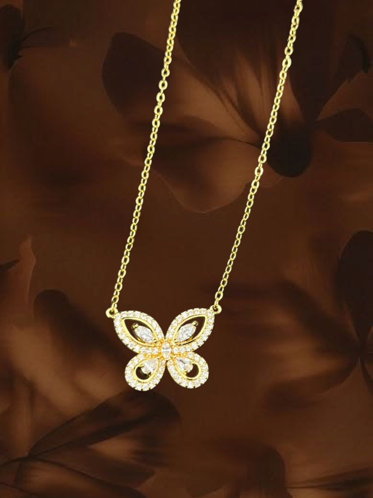 SHE BEAUTY gold-toned butterfly pendant necklace with sparkling white stone accents on a delicate chain