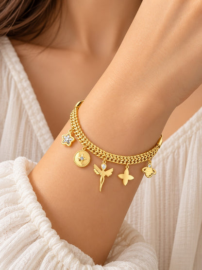 SHE BEAUTY gold-tone chain bracelet featuring dangling charms including a star, angel, and butterfly on a wrist.