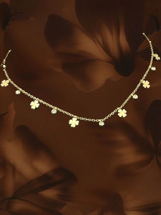 SHE BEAUTY gold-tone chain necklace featuring alternating clover charms and small clear crystals for festive wear.