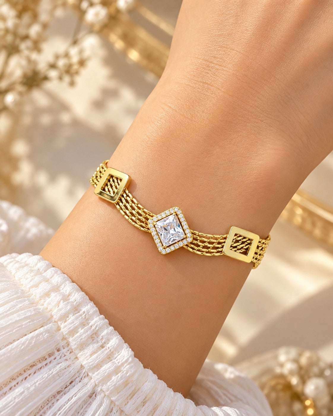 SHE BEAUTY KIYU ZIYU gold-tone multi-strand chain bracelet featuring a central square crystal and geometric accents.