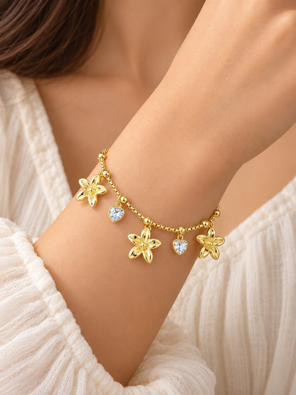 SHE BEAUTY KIYU ZIYU gold chain bracelet featuring dangling flower charms and sparkling heart-shaped crystals