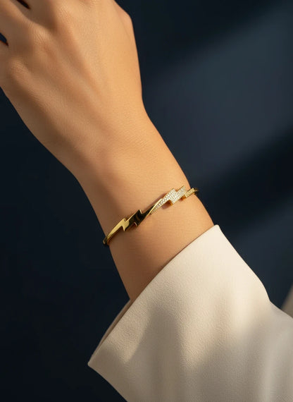 SHE BEAUTY gold-toned anti-tarnish bracelet featuring a sparkling lightning bolt design on a woman's wrist