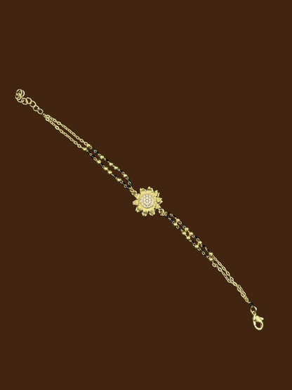 SHE BEAUTY anti-tarnish gold-toned mangalsutra bracelet with a central sunflower-shaped AD stone pendant.