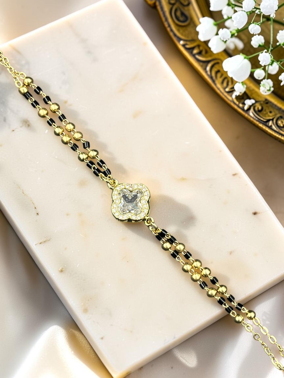 SHE BEAUTY anti-tarnish gold-plated mangalsutra bracelet with a central AD stone clover charm and black beads