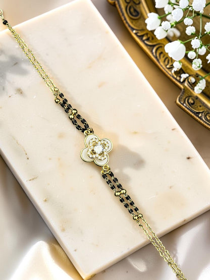 SHE BEAUTY anti-tarnish AD mangalsutra bracelet featuring a gold-tone clover charm with sparkling white stones.